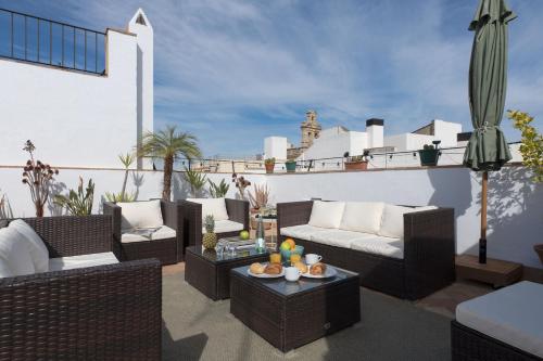 patio z kanapami i stołami na dachu w obiekcie Hommyhome Castellar Luxury w Sewilli