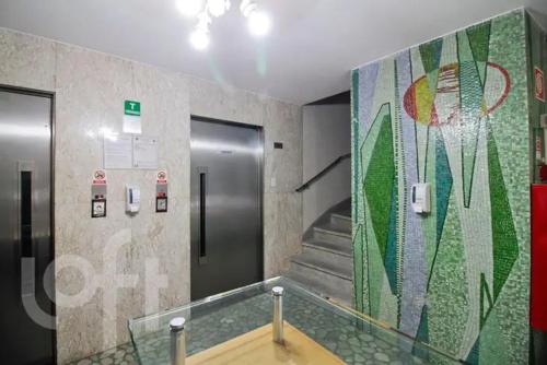 un baño con ascensor y una escalera con una pared de mosaico. en Metro Anhangabaú Sao Paulo - Ótima Localização, en São Paulo