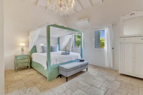 ein Schlafzimmer mit einem Himmelbett und einem Kronleuchter in der Unterkunft Caribbean Lofts Villa in Kralendijk