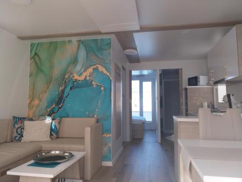 een woonkamer met een bank en een schilderij aan de muur bij Floating Sea House MAREA in Portorož