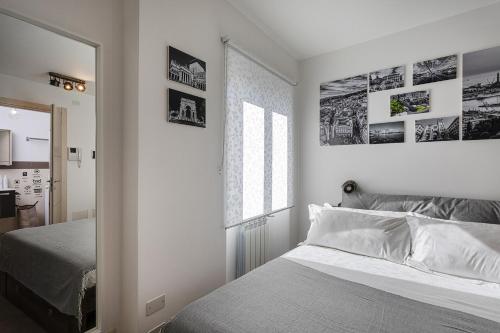 a white bedroom with a bed and a window at Acquarium Studio by Wonderful Italy in Genoa