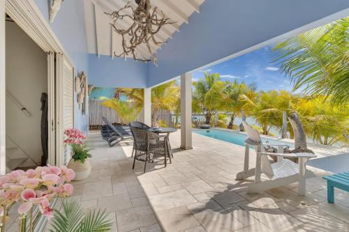 eine Terrasse mit einem Tisch, Stühlen und einem Pool in der Unterkunft Caribbean Lofts Villa in Kralendijk
