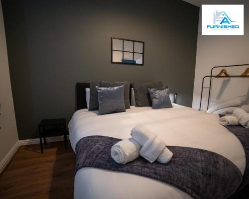 a bedroom with a large bed with towels on it at Contractor Stays by Furnished Accommodation Liverpool - Free Parking in Liverpool
