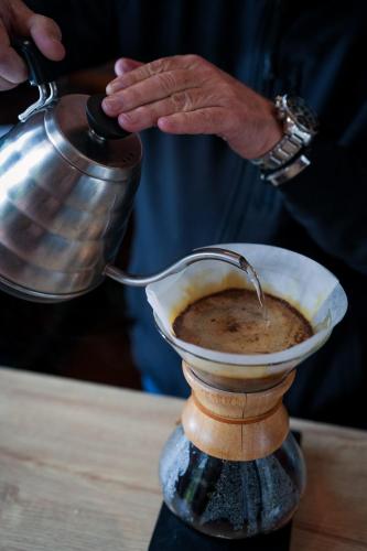 a person is pouring coffee into a pot at Hotel Hacienda Supracafe in Popayan