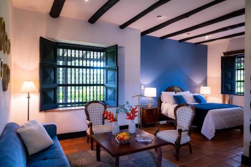 1 dormitorio con 1 cama, mesa y sillas en Hotel Hacienda Supracafe en Popayán