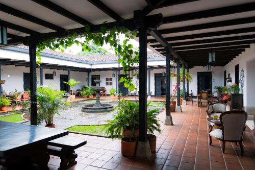 un patio con tavolo, sedie e fontana. di Hotel Hacienda Supracafe a Popayan