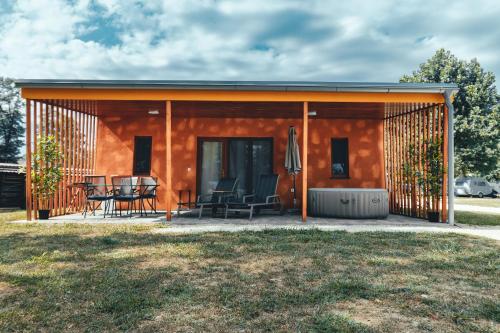 ein kleines Haus mit einer Terrasse in der Unterkunft Terme Banovci - Mobilne hiške Med Brajdami in Banovci