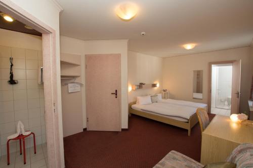 a hotel room with a bed and a bathroom at Hotel Restaurant Escher in Leukerbad