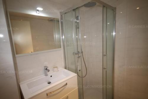 uma casa de banho com um chuveiro, um lavatório e um espelho. em HSUD0118 Terracotta em Cannes