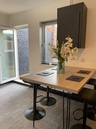 a dining room table with a vase of flowers on it at Byelands Lodge in Middlesbrough