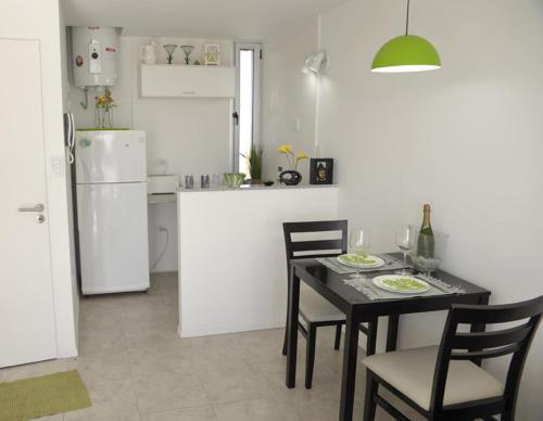 a kitchen with a table and chairs and a refrigerator at Departamento Calle 46 in La Plata