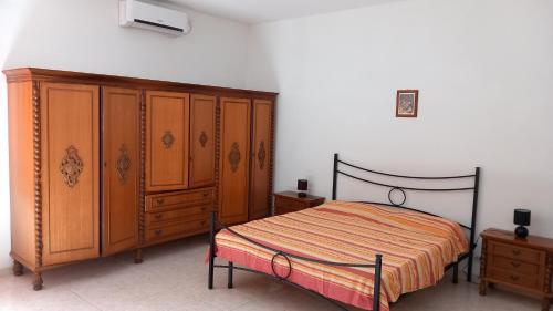 een slaapkamer met een bed en houten kasten bij B&B Il Cortile del Sole in Olmedo