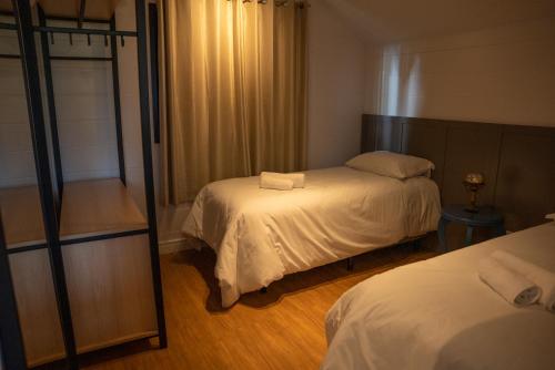 a bedroom with two beds and a mirror at Cabana Serra Grande Sossego in Gramado