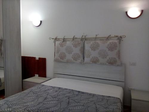 a bedroom with a bed and two lights on the wall at Casa di Agnese in Alghero