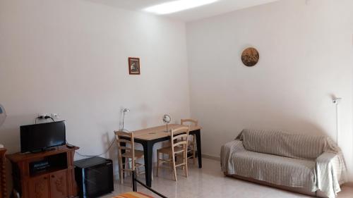 een woonkamer met een tafel en een stoel bij B&B Il Cortile del Sole in Olmedo