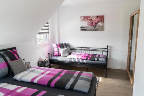 a bedroom with two beds and a tree on the wall at Villa Preisendanz in Ringsheim