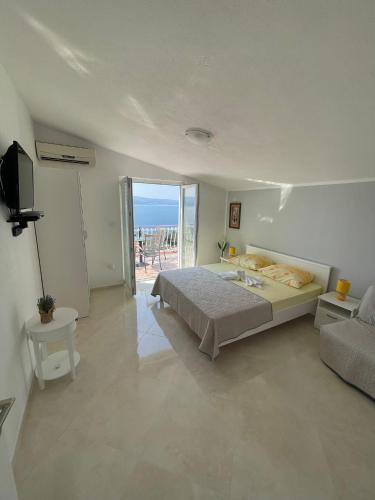 a bedroom with a bed and a view of the ocean at Apartmani ABA in Stanići