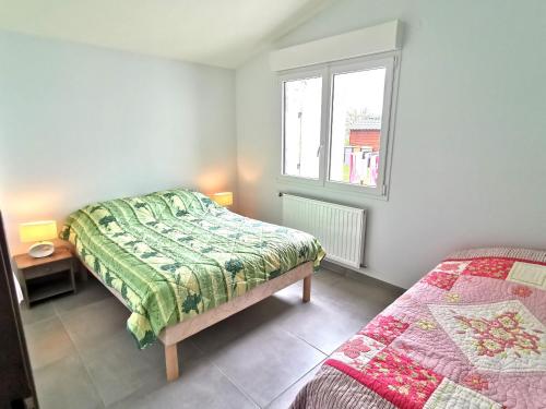 1 dormitorio con 2 camas y ventana en La Belle Evasion - 5 personnes, en Saint-Vincent-sur-Jard