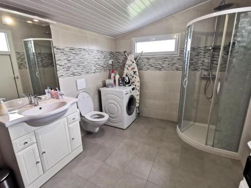 uma casa de banho com um WC com lavatório e um chuveiro em La Belle Evasion - 5 personnes em Saint-Vincent-sur-Jard