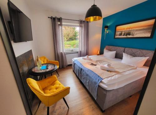 ein Schlafzimmer mit einem großen Bett und einem gelben Stuhl in der Unterkunft Hotel Schwedenkrone in Stade