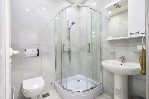 a bathroom with a shower and a toilet and a sink at Apartmani Joja in Kuršumlija