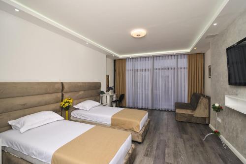 une chambre d'hôtel avec deux lits et une chaise dans l'établissement Apartmani Joja, à Kuršumlija