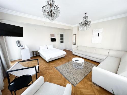 una sala de estar con muebles blancos y una lámpara de araña. en Avlu Tophane, en Bursa