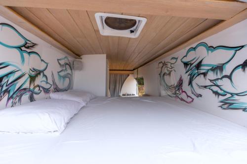 1 dormitorio con 2 camas con graffiti en la pared en Vive La Van, en San Juan