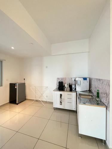 a kitchen with a sink and a refrigerator at METROPOL SERVICED APARTMENT at Bukit Mertajam, Pulau Pinang in Bukit Mertajam