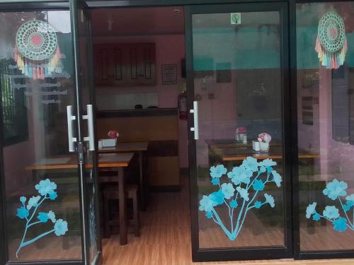 two glass doors with blue flowers painted on them at Roseville Home Stay and Tour Agency Tabaco City in Baranghauon