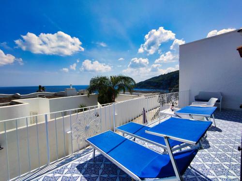 Un balcón con sillas azules y vistas al océano. en La Caura di Casa Camilla Journey en Marina Serra