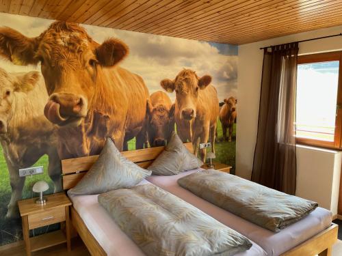 a bedroom with a mural of cows on the wall at Pension Altvogtshof in Eisenbach