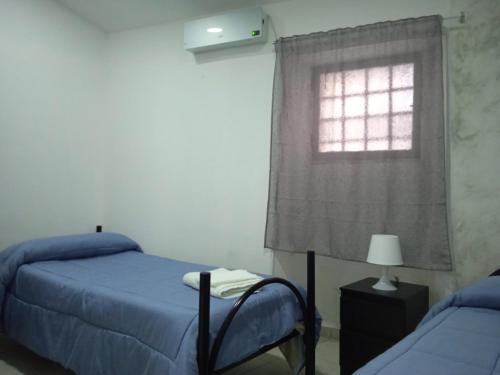 a bedroom with two beds and a window at Case Serena vacanze relax in Catania