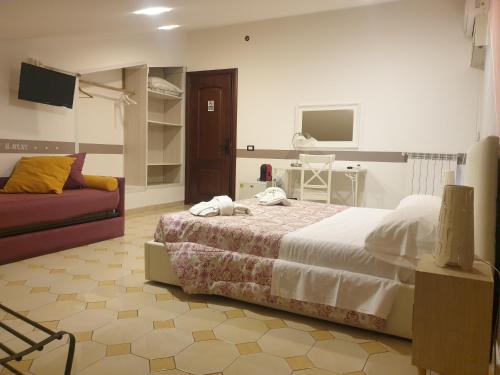 um quarto com uma cama e um sofá em Dimoramuri B&B em Catânia