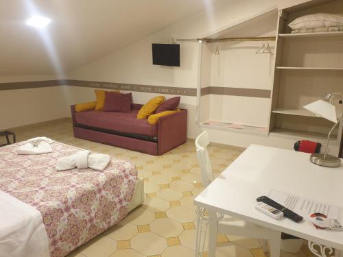 um quarto com uma cama, um sofá e uma mesa em Dimoramuri B&B em Catânia