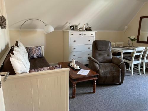 ein Wohnzimmer mit einem Sofa, einem Stuhl und einem Tisch in der Unterkunft Ferienwohnung Strandgut in Prerow
