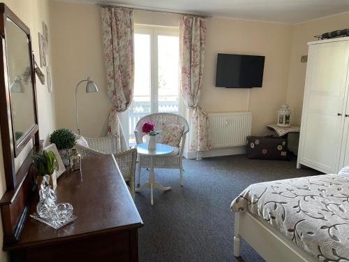 ein Hotelzimmer mit einem Bett und einem Tisch sowie einem Zimmer in der Unterkunft Ferienwohnung Strandgut in Prerow