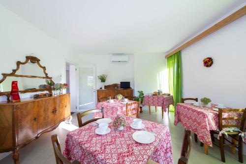 uma sala de jantar com duas mesas com toalhas cor-de-rosa em B&b Stregatto dalla Luna em Feltre