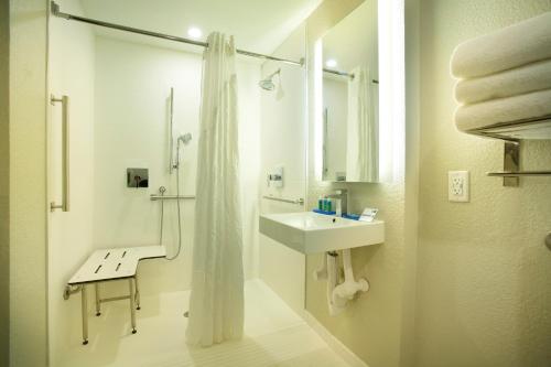 a white bathroom with a sink and a shower at Holiday Inn Express & Suites S Lake Buena Vista, an IHG Hotel in Kissimmee