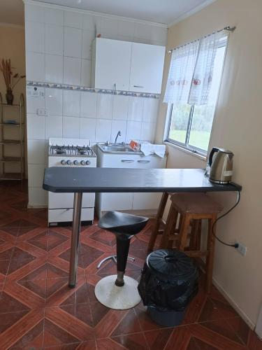 a kitchen with a table and a sink and a stove at Huerto El Tránsito in El Portillo