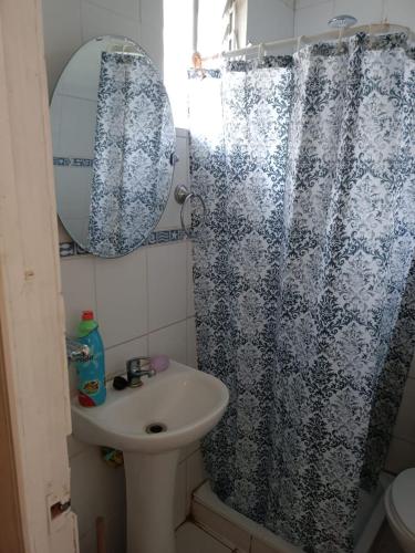 a bathroom with a sink and a shower curtain at Huerto El Tránsito in El Portillo