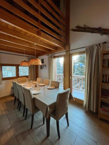 - une salle à manger avec une table, des chaises et des fenêtres dans l'établissement Chalet with mountainview, à Oz
