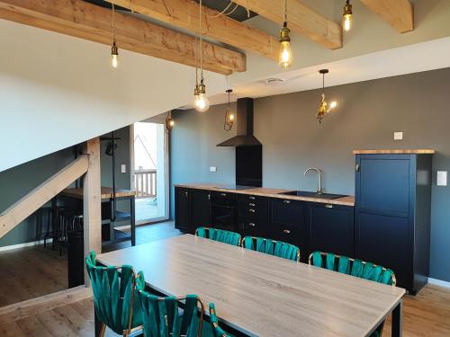 une cuisine et une salle à manger avec une table et des chaises en bois dans l'établissement L'Horizon, à Bergheim