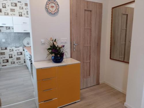 a room with a yellow dresser with a vase on it at New holiday home in Nowe Warpno for 10 people in Nowe Warpno