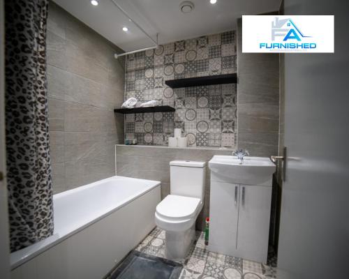 a bathroom with a toilet and a bath tub and a sink at Insurance Stays by Furnished Accommodation Liverpool - Family Home in Liverpool