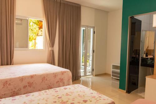 a bedroom with two beds and a window at Casa em cond fechado em Barra de Santo Antonio AL in Barra de Santo Antônio