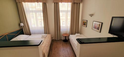 a small room with two beds and a television at Hotel Malá Strana in Prague