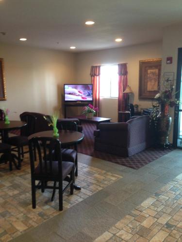 a living room with a couch and tables and a tv at Americas Best Value Inn Somerville Texas in Somerville