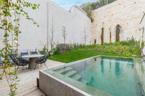 einen Pool in einem Garten mit einem Tisch und Stühlen in der Unterkunft Hidden Pearl W/ Patio & Pool by LovelyStay in Lissabon