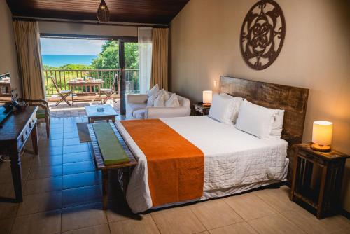 a bedroom with a bed and a living room at Oka Da Mata in Pipa